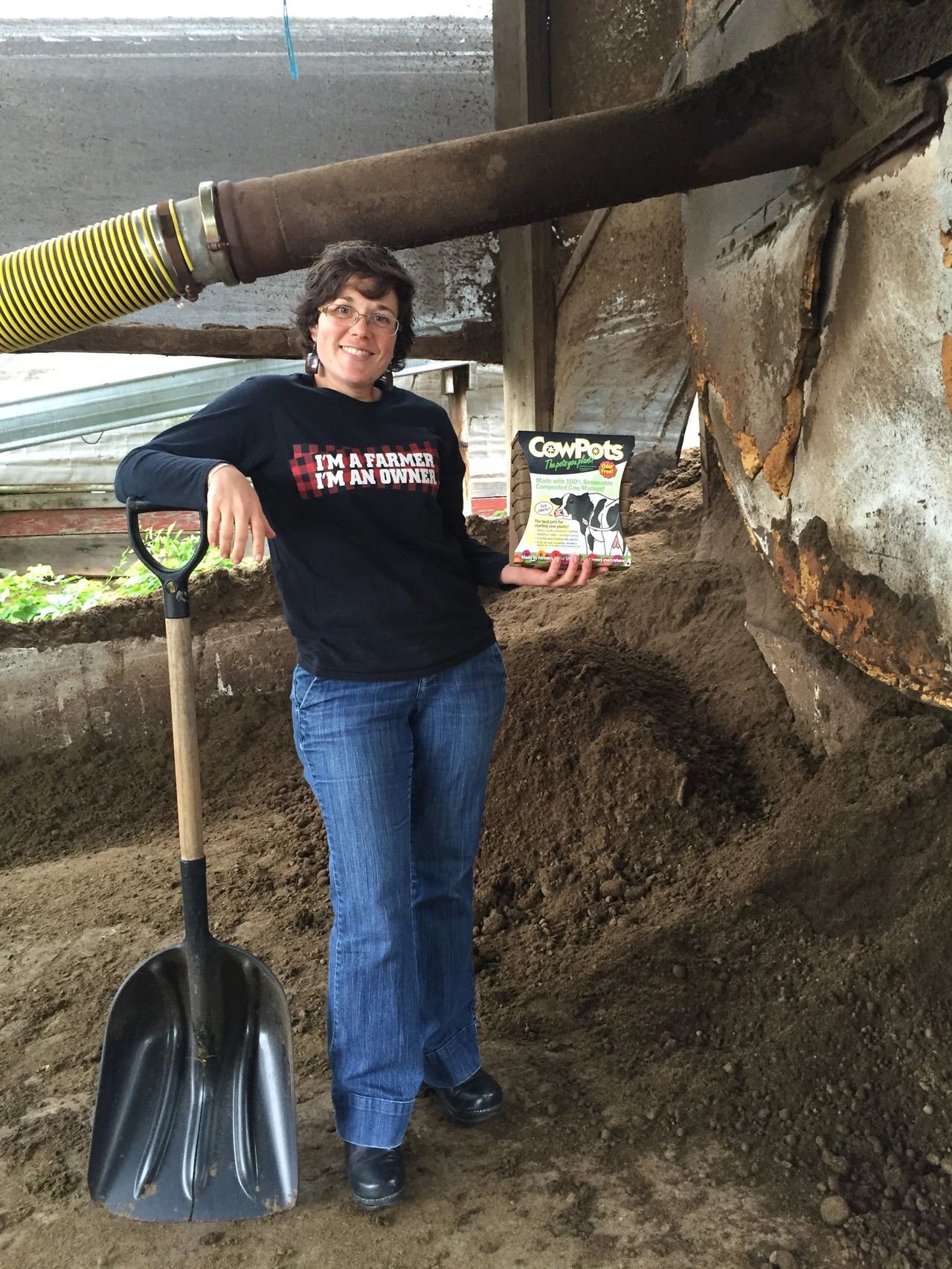 CowPotsGirl shovels Compost and shows off finished CowPots product.